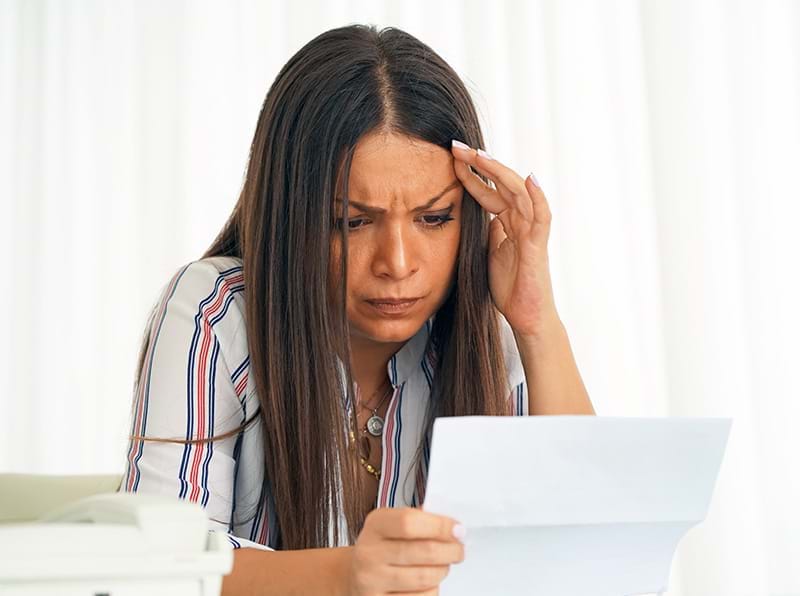 Woman with shocked face receiving a non-filing notice in the mail